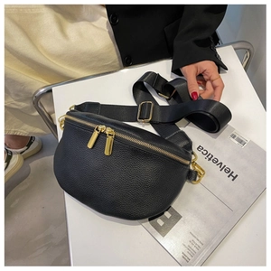 Detail of black lychee grain leather crossbody bag with dual gold zippers and wide strap