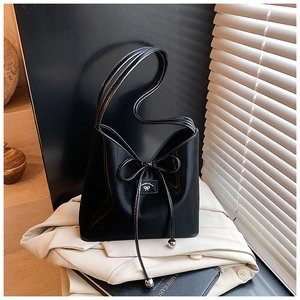 Détail du sac seau noir verni avec cordon à nœud et pendentifs sphériques en métal argenté
