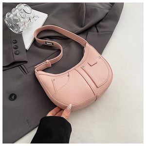 Detail of pink lychee leather dumpling bag showing metal rivets and adjustable strap