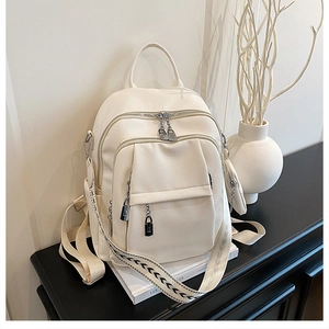 Detail of off-white lychee texture leather backpack with wide patterned shoulder strap