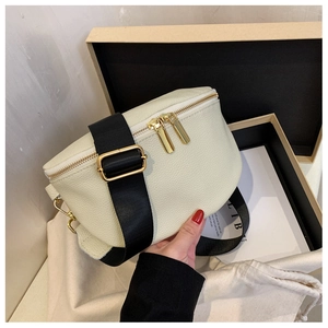 Detailed view of cream pebble leather crossbody bag with gold hardware and packaging