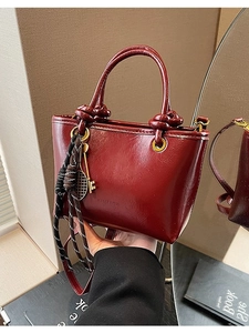 Sac seau rétro bordeaux brillant avec détails dorés et porte-clés décoratif