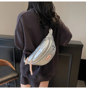 Borsa a tracolla argento metallizzato con occhi cartoon indossata su una modella