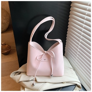 Détail du sac à bandoulière en cuir rose clair avec cordon nœud et accents de perles argent