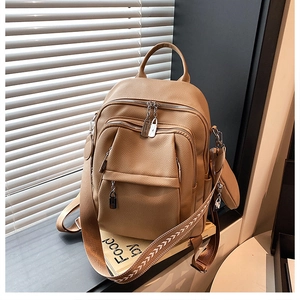 Detail of khaki leather backpack with lychee texture and ethnic style woven strap