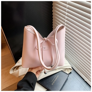 Détail du sac seau en PU rose avec nœud papillon et breloque en perles métalliques