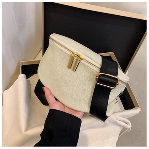Detail of off-white lychee leather chest bag with golden zippers and wide black nylon strap