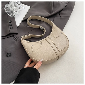 Detail view of beige lychee texture leather shoulder bag with chic metal rivet accents