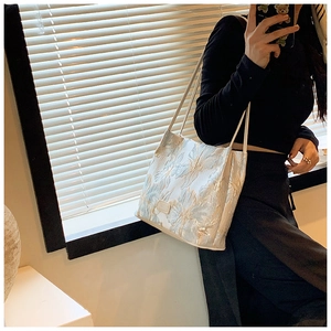 Close-up of beige Hanfu bucket bag with floral jacquard texture and shoulder straps