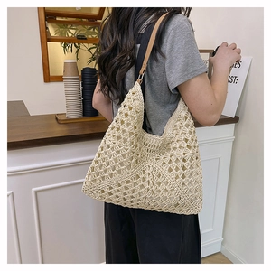 Detail of hand-crocheted straw tote bag with brown leather handles in a cafe setting
