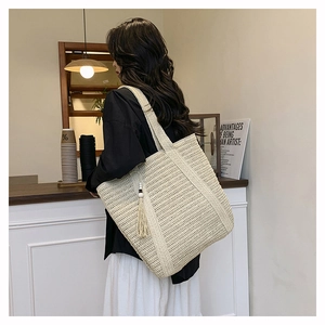 Detail of a beige woven tote bag with fringe tassel in a cozy cafe setting