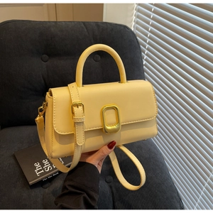 Détail du mini sac à main rétro jaune clair avec fermoir doré et texture en cuir lisse