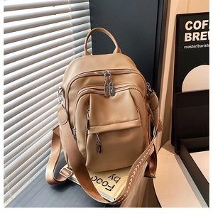 Detail of beige pebble leather backpack with arrow-patterned straps and side pocket