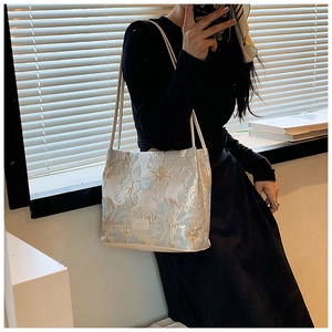 Detail of floral jacquard tote bag with elegant blue and gold embroidery patterns