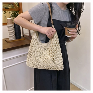 Detailed close-up of beige crochet tote bag featuring intricate floral hollow patterns