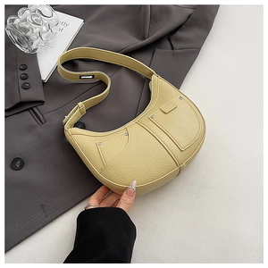 Detailed macro view of beige hobo bag with pebble leather texture and decorative pockets