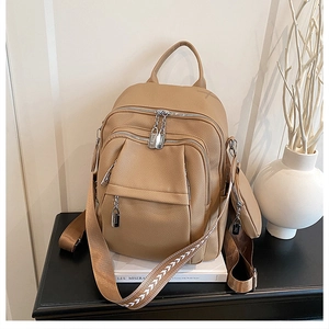 Detail of camel lychee textured leather backpack with silver lock and mini coin purse