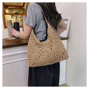 Detail of hollow crochet texture on light khaki woven tote bag for summer beach travel