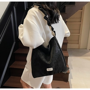 Detail of the oversized ruffled shoulder strap on the black matte hobo tote bag
