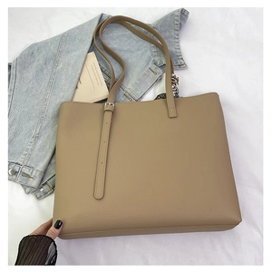 Close-up of khaki tote bag featuring lychee texture and silk scarf accessory on handles