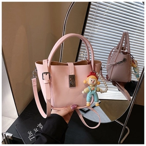 Detailed shot of pink bucket bag with pearl chain, doll pendant and silver twist lock