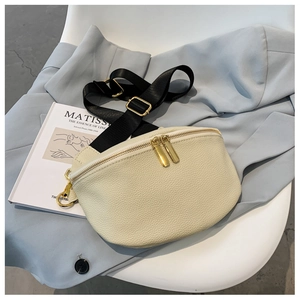 Detail of cream-white lychee texture crescent bag with gold zippers on a blue blazer