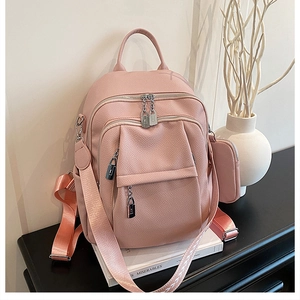 Pink lychee grain leather backpack detail with silver metal locks and removable small pouch