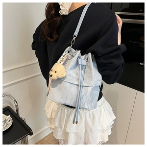 Light blue pleated bucket bag detail with adjustable strap and cute plush dog charm