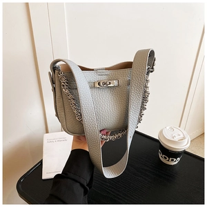 Dettaglio della borsa a secchiello grigio chiaro in pelle martellata con chiusura a scatto