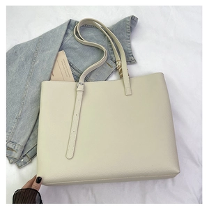 Detail view of large cream tote bag with lychee leather texture and silver buckle strap