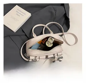Top view of cream bowling bag interior with perfume bottles and ribbon details
