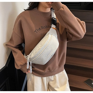 Close-up of white canvas waist bag with LanMaidi embossed logo and dual zipper detail