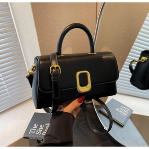 Détail du sac à main en cuir noir avec boucle dorée et bandoulière réglable pratique