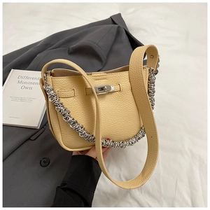 Dettaglio di borsa in pelle litchi giallo chiaro con chiusura a scatto argento