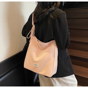 Detail of light pink large hobo bag with MULAIDI woven label on matte fabric texture