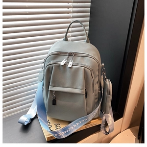 Close-up of luxury grey-blue backpack with textured leather and woven pattern strap