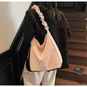 Pink large hobo tote bag with ruffled shoulder strap shown on model in stylish setting