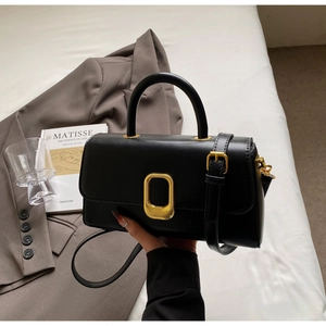 Gros plan du sac à bandoulière en cuir noir avec boucle métallique dorée élégante
