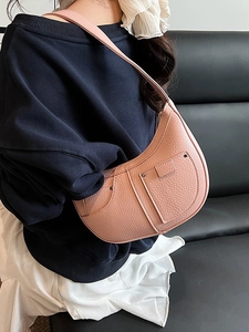 Pink crescent shoulder bag in lychee texture leather with utility pockets and stitch detail