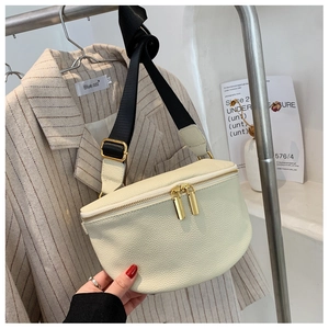 Detail of cream pebbled leather chest bag with golden zippers and black nylon strap