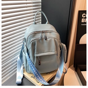 Detail of light blue lychee pattern leather backpack with woven strap and side pouch