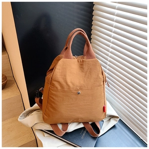 Detailed view of camel nylon backpack with dual handles and water-resistant wrinkled texture