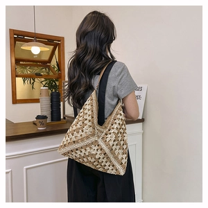 Detail of bohemian geometric woven hobo bag showing crochet patterns and relaxed shoulder fit