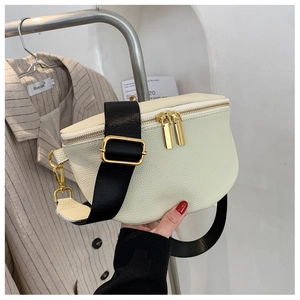 Close-up of off-white lychee grain waist bag with gold zippers and black nylon strap