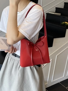 Sac à épaule en cuir verni rouge avec cordon de serrage à nœud et logo élégant en relief