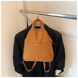 Detail of ginger yellow nylon sling bag showing metal buckle and waterproof texture