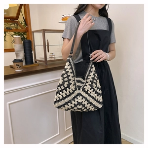 Close-up of handmade crochet straw tote bag showing checkered texture and leather strap