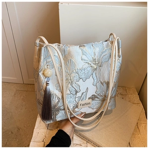 Detailed close-up of light blue floral jacquard embroidery bucket bag with silk tassel