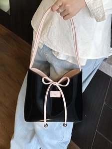 Sac bandoulière chic en cuir verni noir avec nœuds roses et longues anses pour femmes