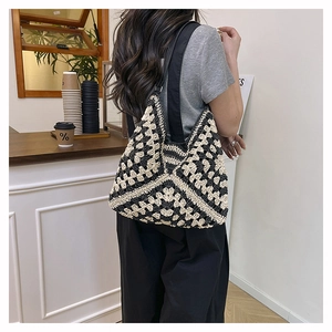 Detail of hand-crocheted black and white geometric pattern on a knit tote bag